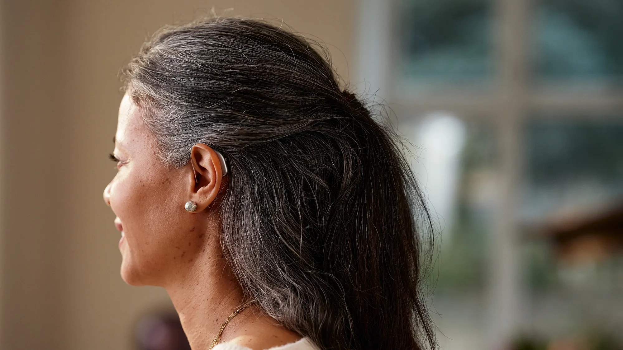 Widex Allure hearing aids shown on ear to illustrate how small they are.